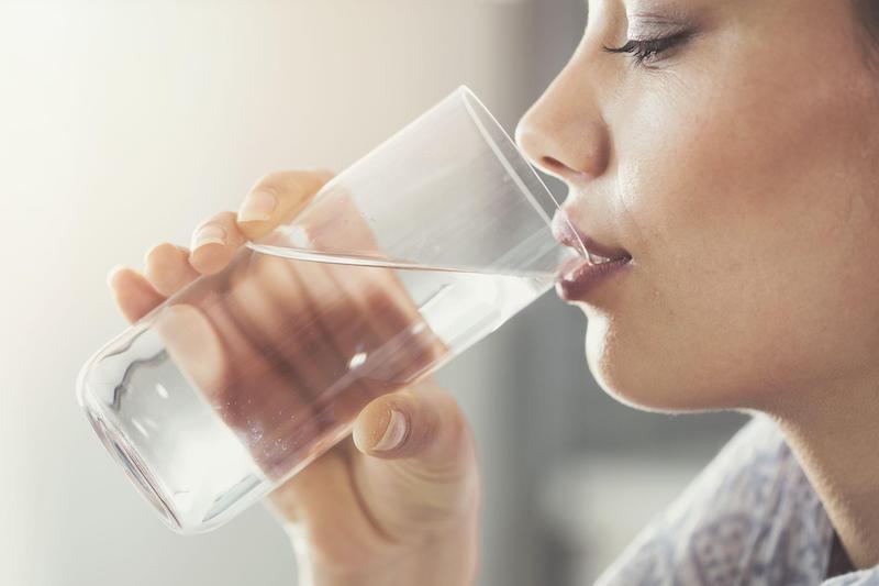woman drinking clean water from Rainsoft Water Filtration System