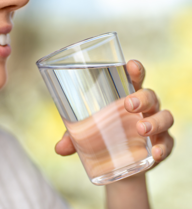 Person holding a glass of drinking water