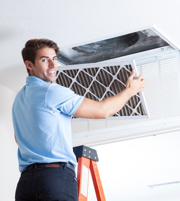 Worker removing air filter from HVAC unit