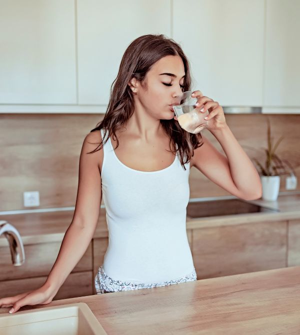 Woman drinking water in kitchen
