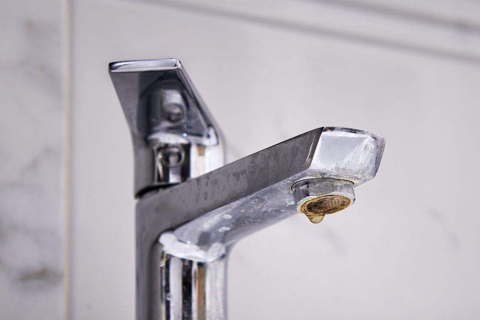 old limescale on tap faucet because of hard water.