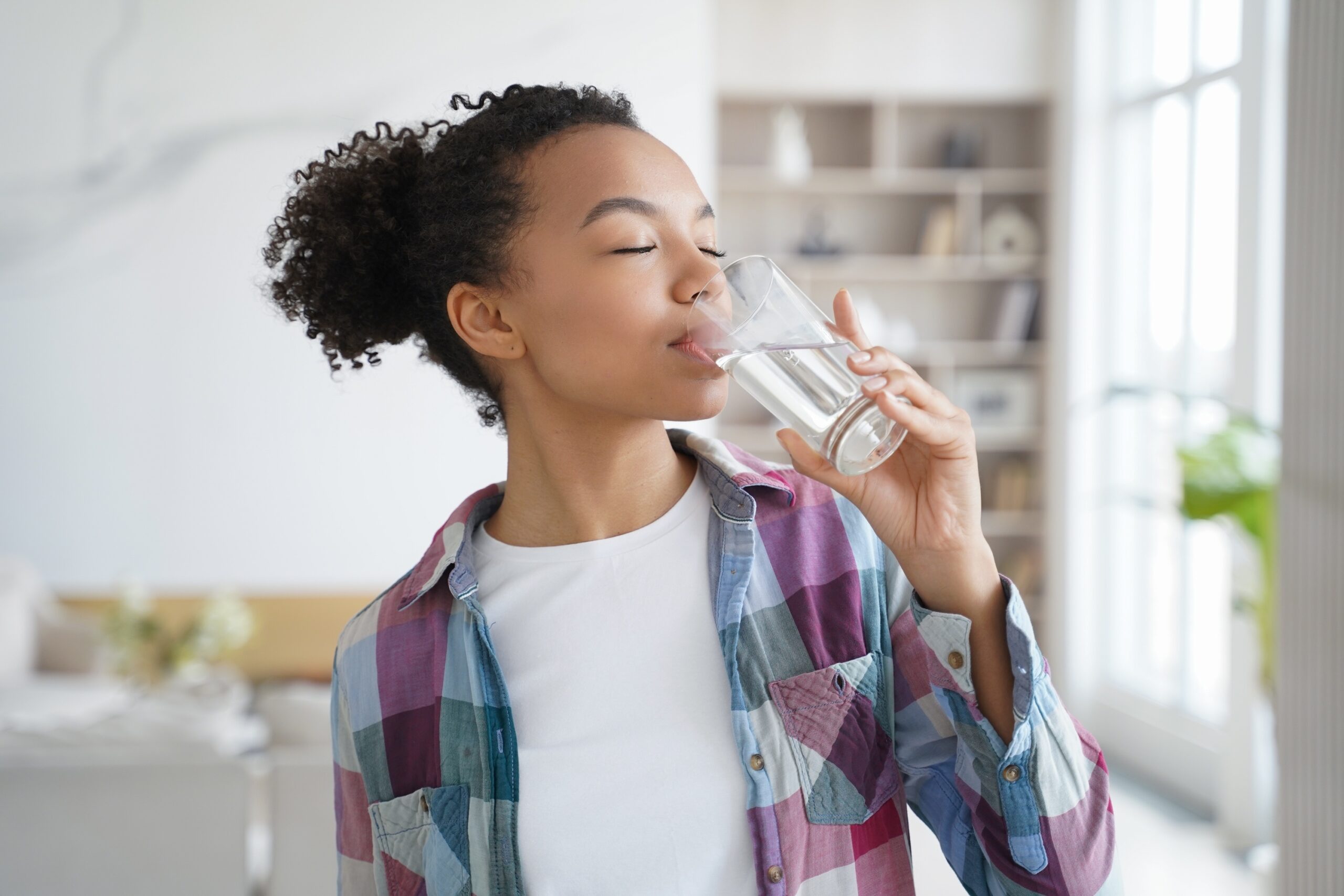 African american woman enjoy drinking pure crystal purified water.